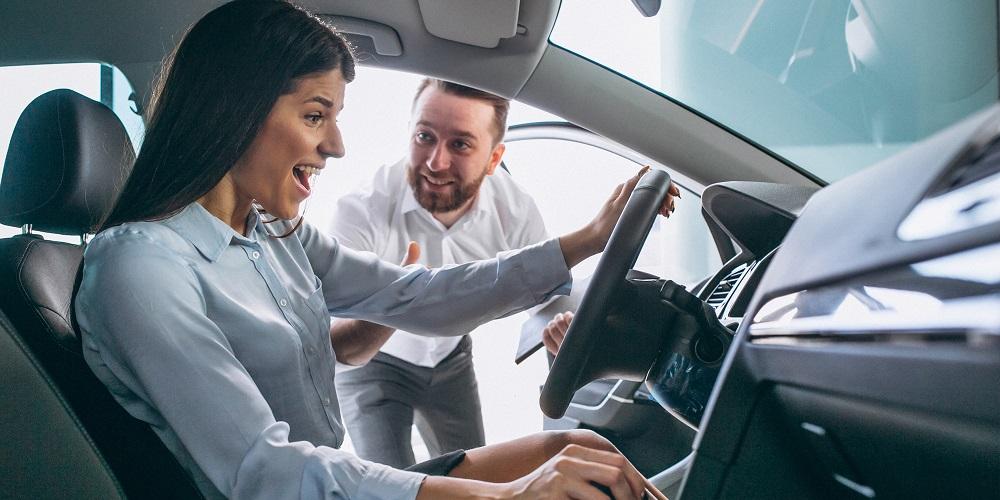 mulher feliz comprando um carro de um vendendor de concessionária