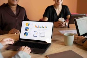 Equipe analisa gráficos e resultados em reunião sobre estratégias de SEO para empresas
