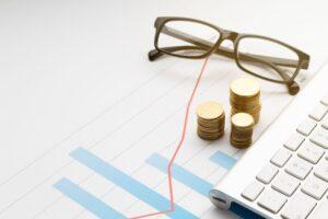 Imagem com óculos, moedas e gráficos representando o que é taxa Selic