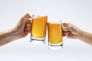 Duas pessoas brindando com copo de cerveja