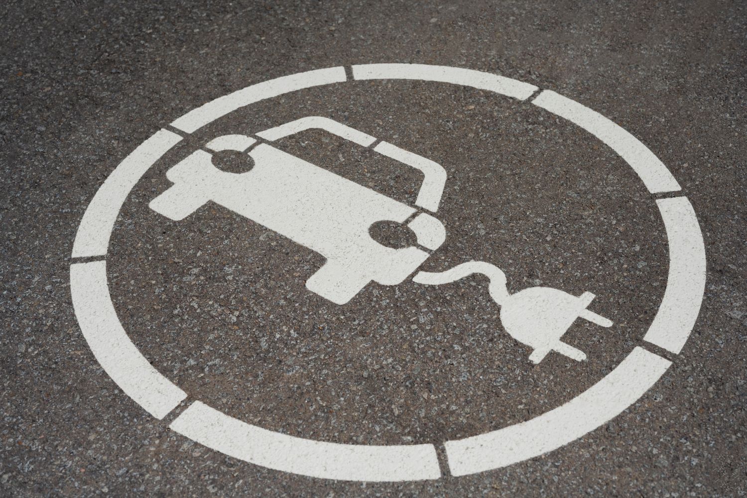Imagem de um carro com fio para se conectar à tomada desenhada no chão