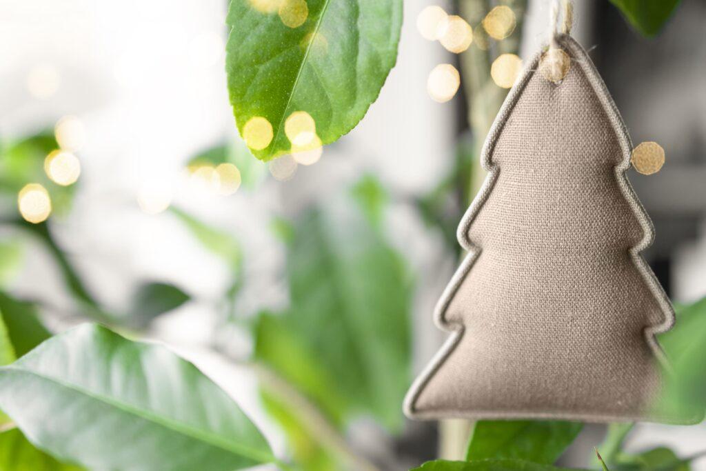 Árvore de Natal ecológica com folhas naturais e itens decorativos de pano que demonstra uma decoração natalina sustentável