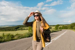 A imagem mostra uma mulher em uma estrada, indo viajar e conhecer os melhores lugares do Brasil.