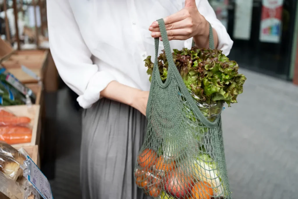 Mulher segurando uma sacola com verduras sustentáveis 