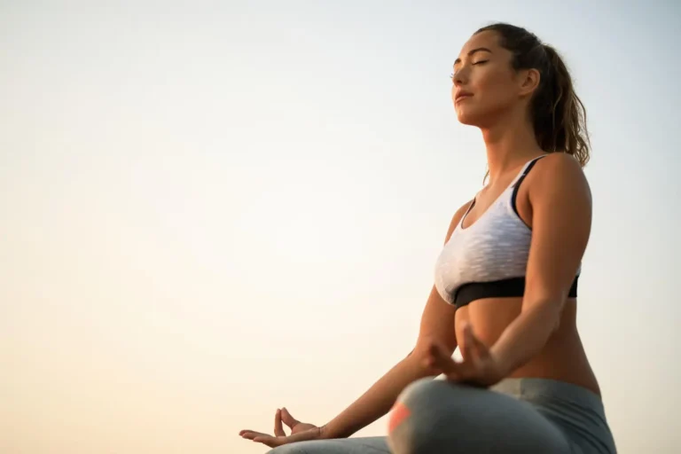 A imagem mostra uma mulher meditando após conhecer os benefícios da prática.