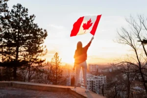Mulher que conseguiu um intercâmbio no Canadá segurando uma bandeira do país