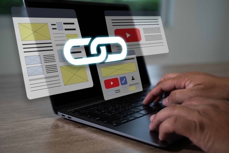Profissional em notebook com símbolo de conexão entre páginas, representando estratégia de link building