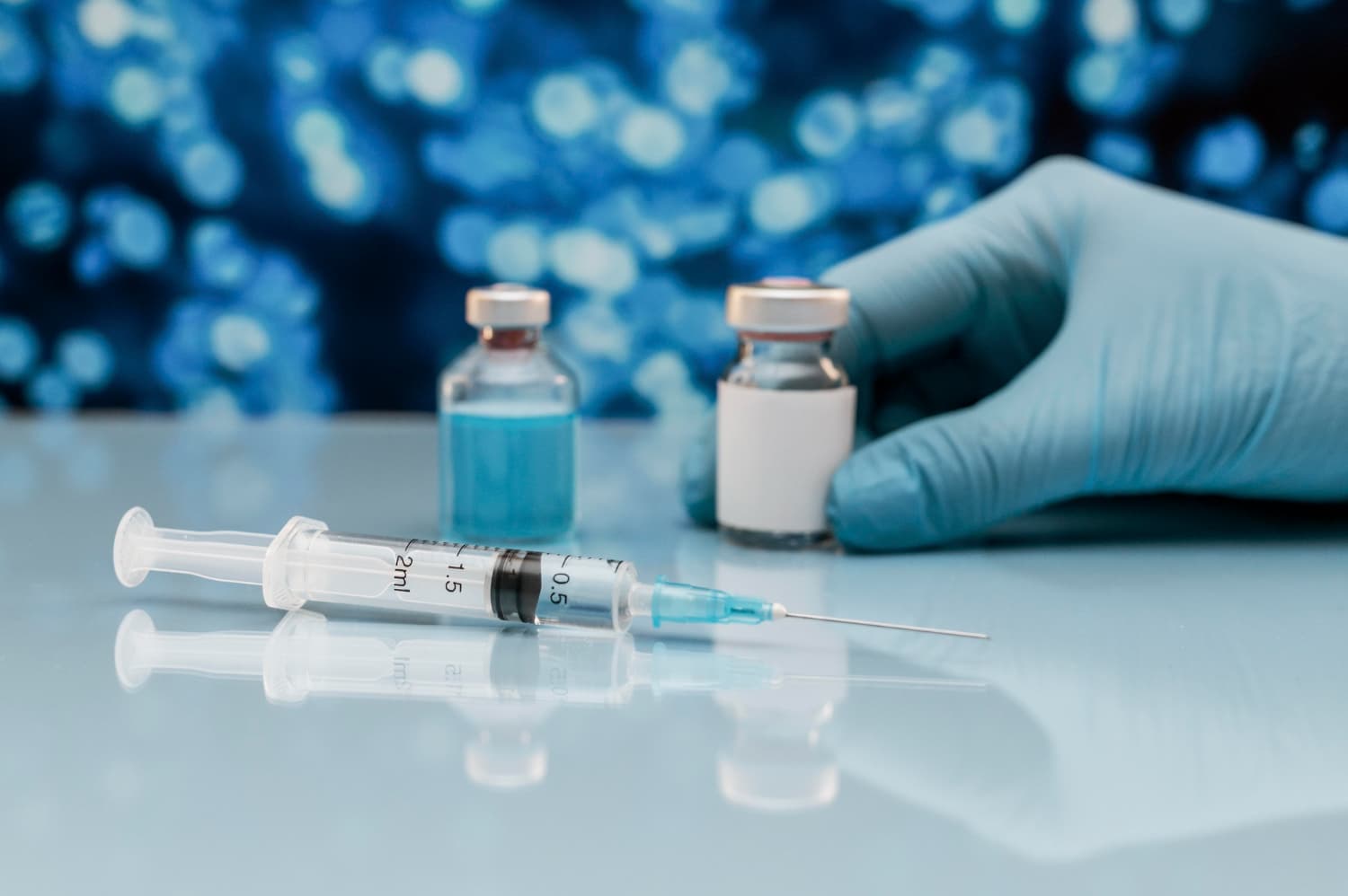 Profissional de saúde segura frasco de remédio ao lado de seringa com medicamento importado